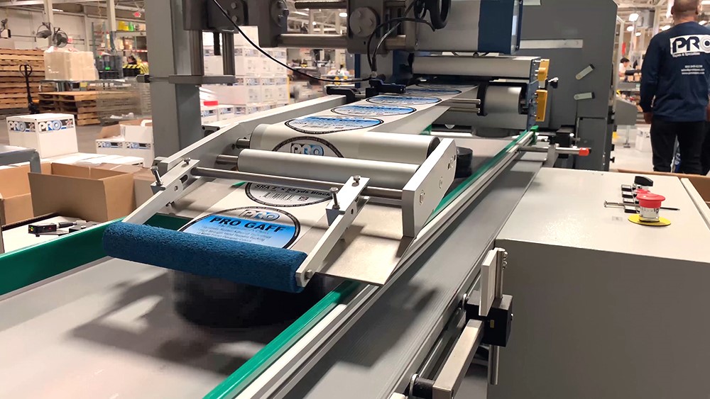 Inline shrink wrapping and automated labeling system from single rolls to multi roll 2, 4 or 6 roll configurations.