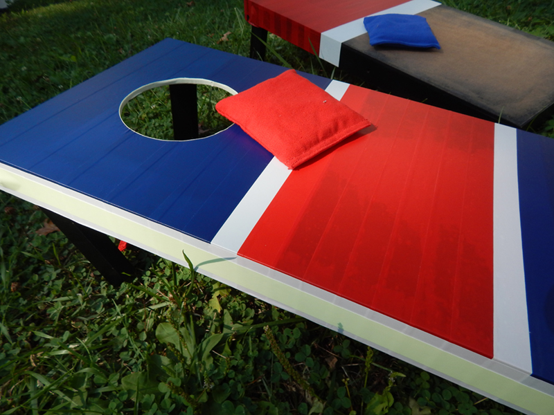 The cornhole game boards and a bean bag, after the boards have been decorated with Pro Splice tape