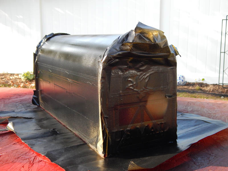 Spray painting the mailbox after masking with tape, part 2