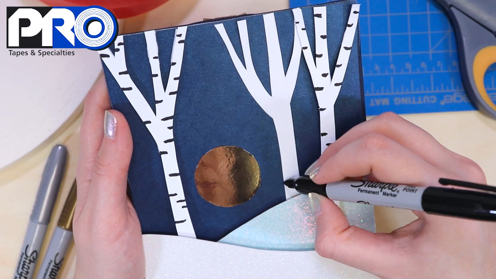 Use a black Sharpie to create a birch tree pattern in the trees