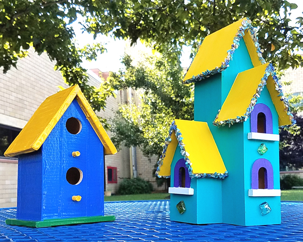 Two beautiful birdhouses created by our resident artist, Becky Sarkozy. One is small and simple, the other is tall and has extra embellishments